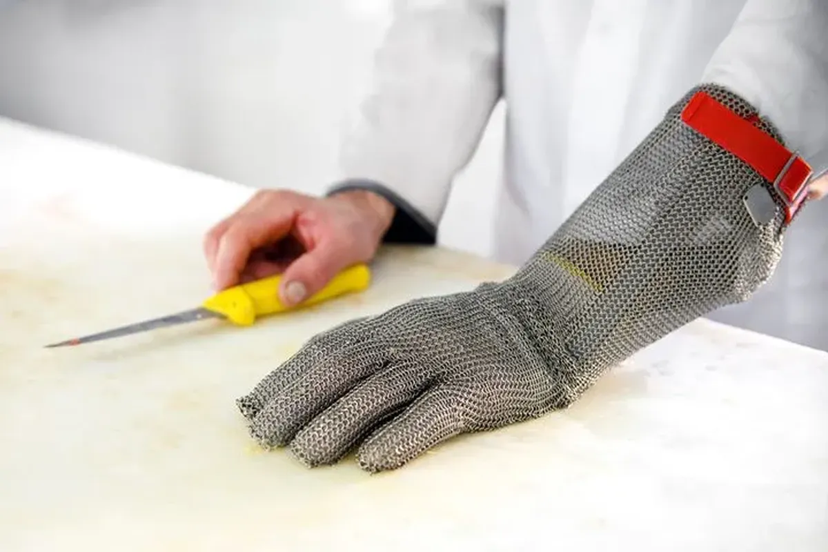 Food processing worker wearing cut-resistant gloves and protective clothing
